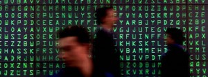 VISITORS PASS A VIDEOSCREEN WITH MOVING LETTERS AT CEBIT FAIR IN HANOVER.